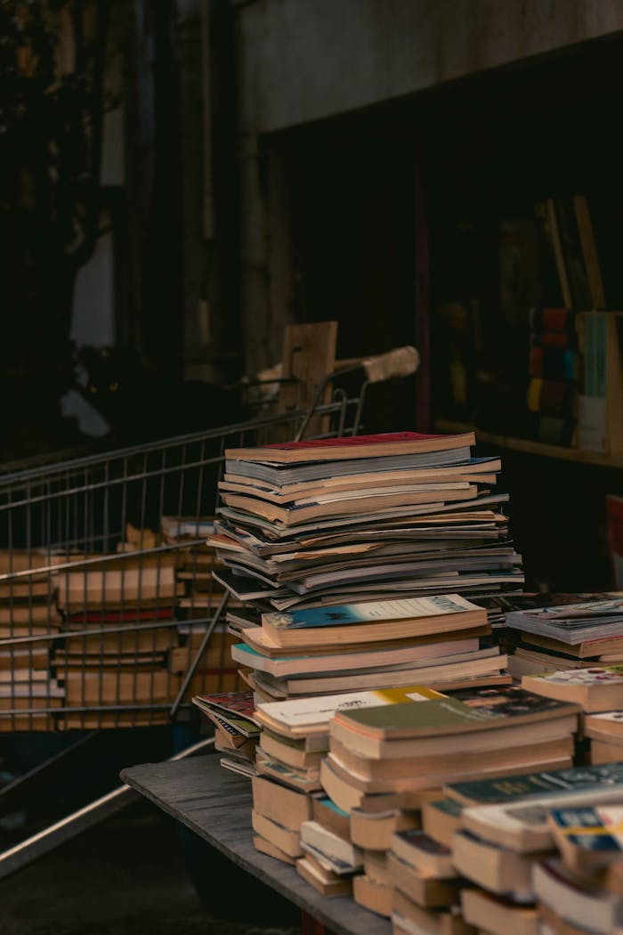 A stack of old books on a table in a dimly lit Istanbul street market.